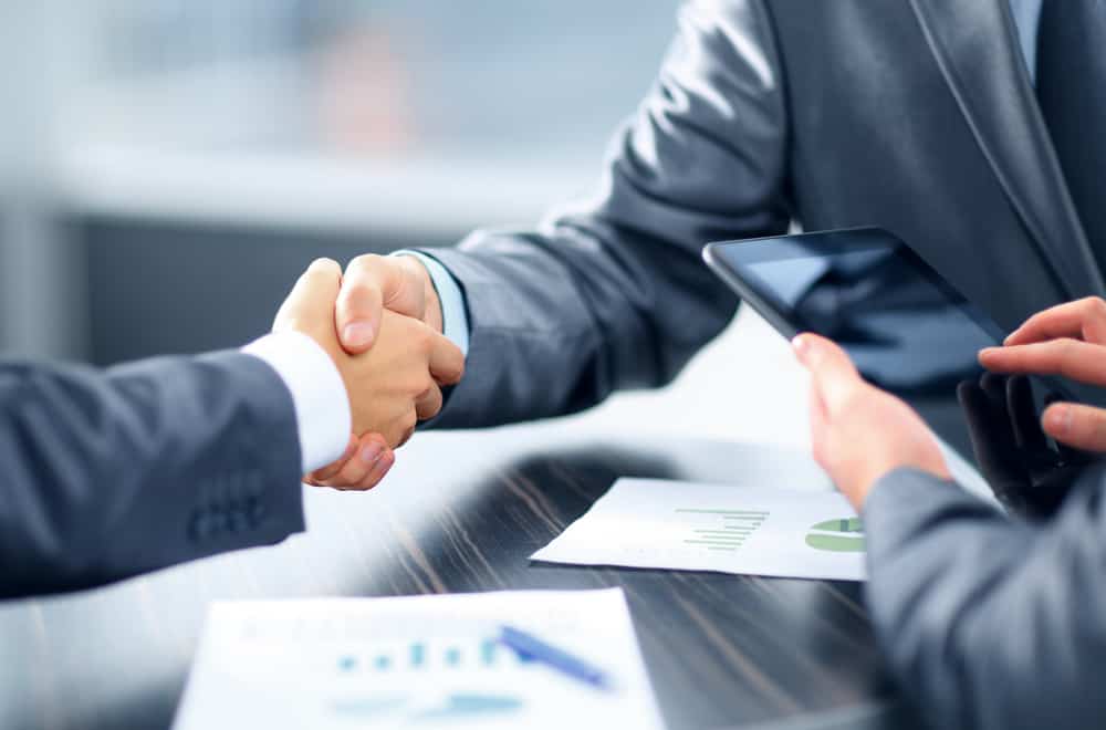 taxing Taking Money Out of Your Corporation Can Cost You If Not Done Properly. This is a picture of business men shaking hands on an agreement. 